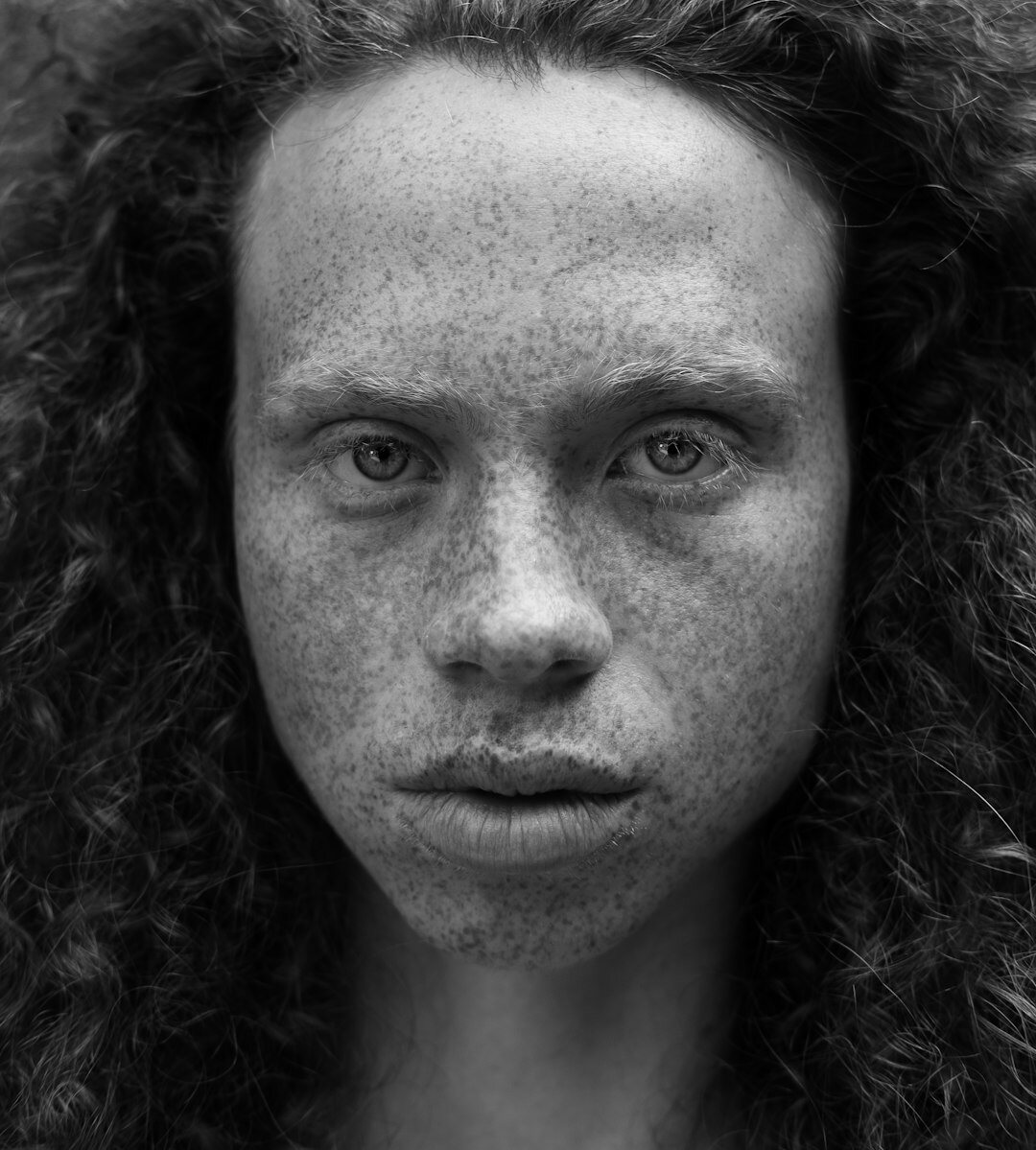 Studio portrait of a smiling Brazilian woman with curly hair