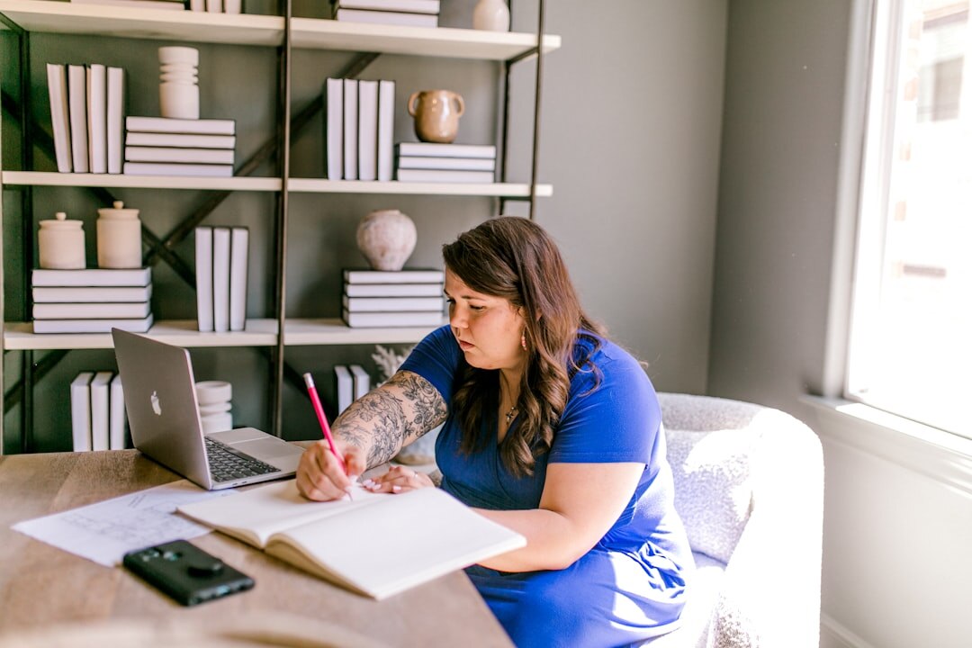 Woman writing notes at a bright desk while reflecting on her personal growth