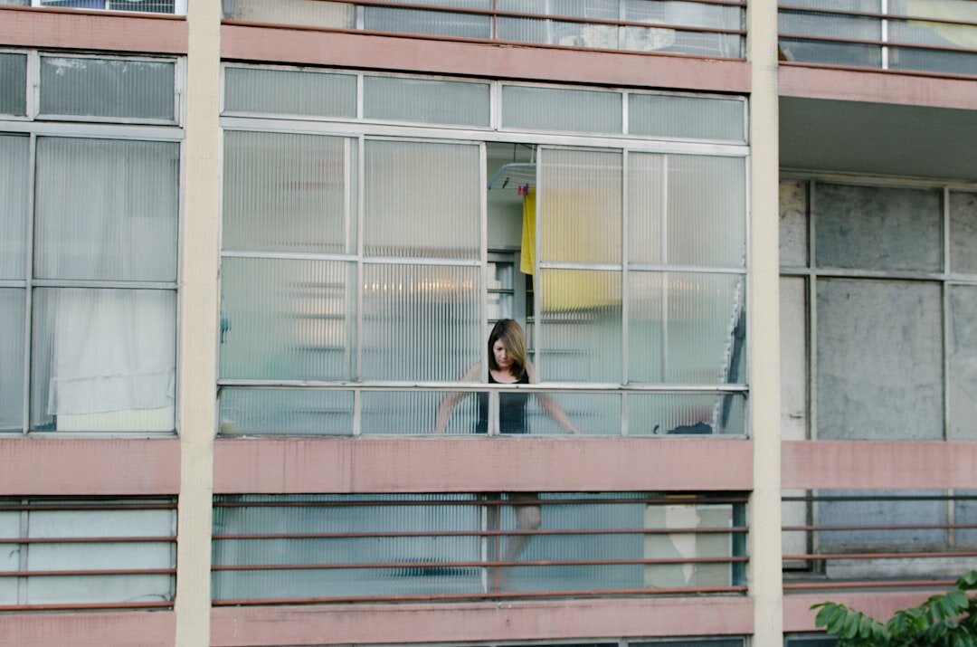 Brazilian woman sitting by a window looking thoughtful and calm