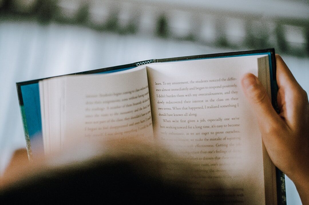 person reading book at home